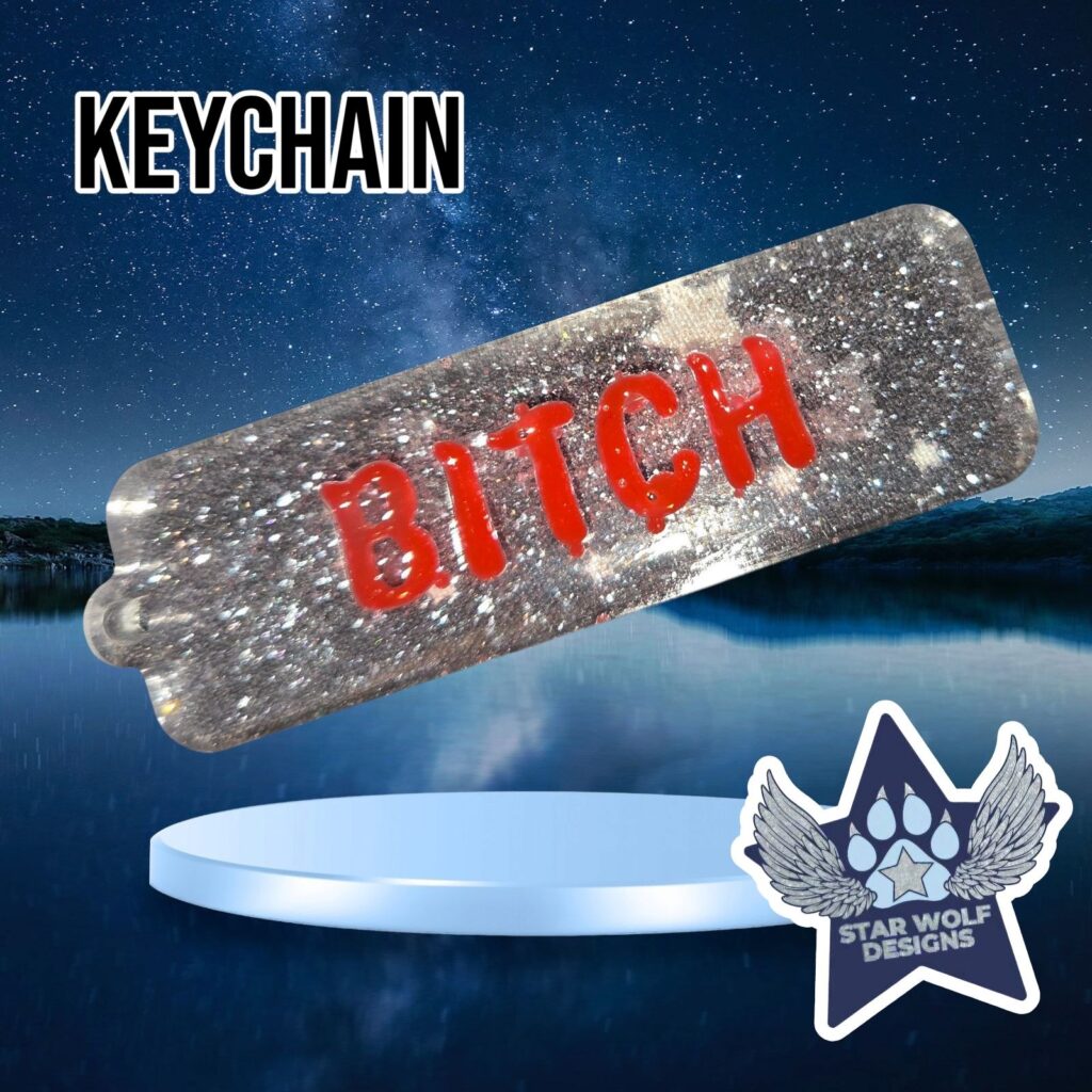Silver glitter keychain reading “Bitch”